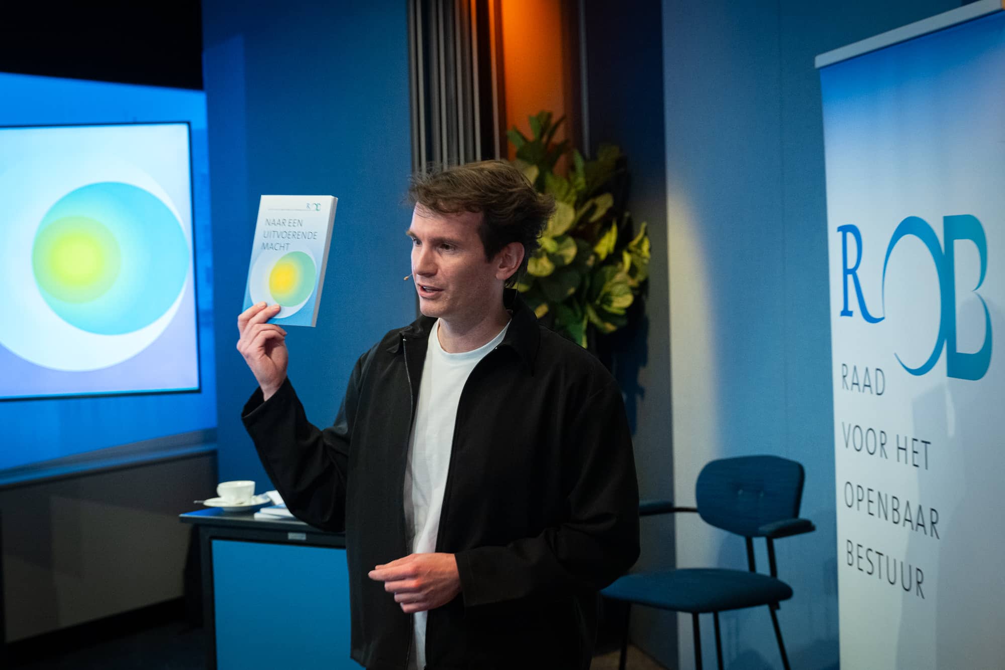 Dagvoorzitter Tom Jessen houdt het boekje omhoog